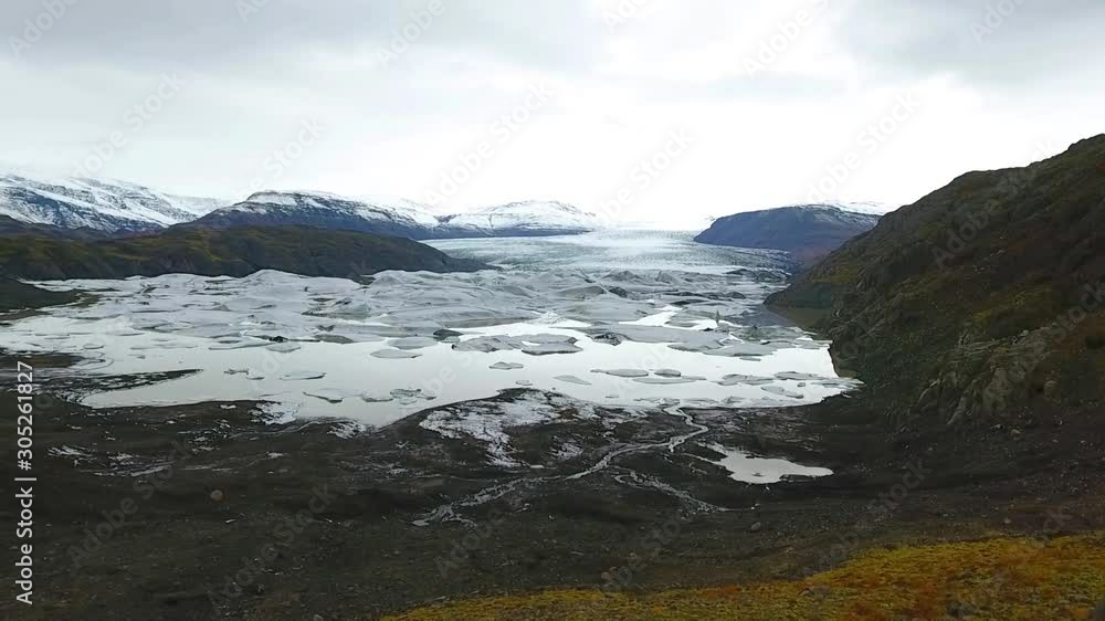 Aerial top view of the ridges of white glacier with black ash. Scenic iceberg in national park in Iceland. Aerial top view of the ridges of white glacier with black ash. Scenic iceberg in national park in Iceland.