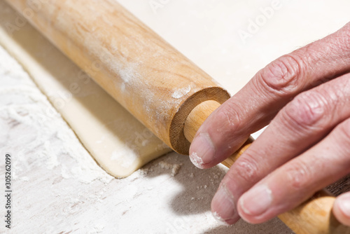 the process of rolling dough. hands and rolling pin, selective focus