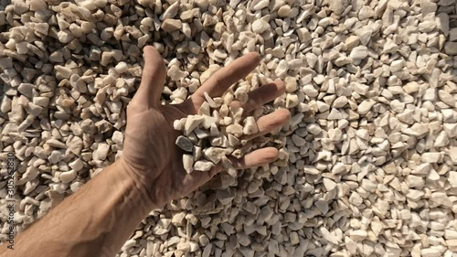Man holds white crushed marble stone