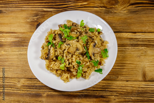 Tasty risotto with mushrooms on wooden table. Top view