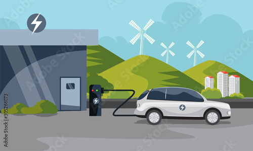 electric car charging at the charging station with wind turbines and city