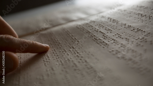 Billede på lærred The hand of a blind man reads the text of a braille book.