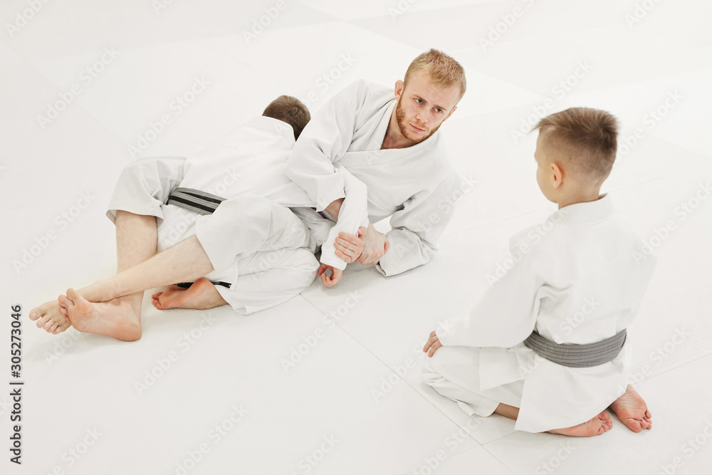 Young coach showing the technique to his students during training isolated on white background Young coach showing the technique to his students during training isolated on white background