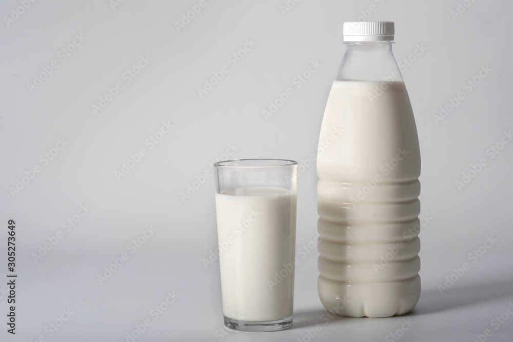 Glass of milk and a bottle on a gray background. Dairy products