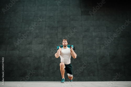 Man doing exercises with weight bag.
