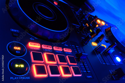 Obraz na płótnie Dj consolle, audio mixer, con luci colorate da discoteca. Particolare tasto hot cue. w salonie
