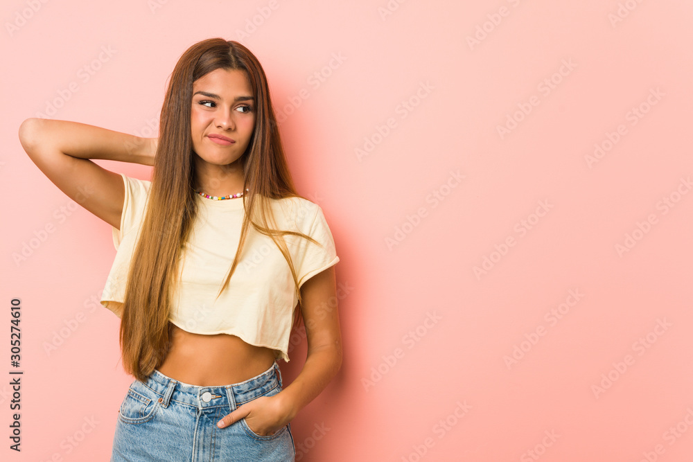Young slim woman touching back of head, thinking and making a choice. Young slim woman touching back of head, thinking and making a choice.