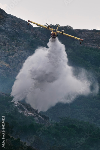 Hidroavion o avion anfibio (FOCA) realizando descarga de agua en incendio forestal