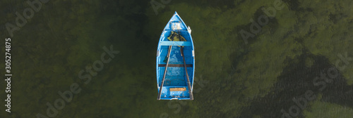 Obraz na płótnie Blue rowing boat top down aerial with ocean background