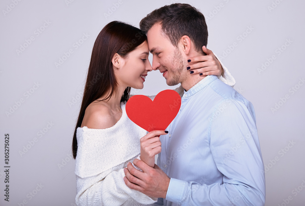 Close up of a hugging couple with a red heart.