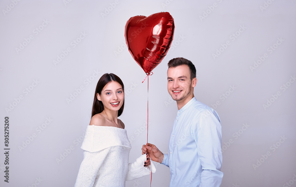 Happy lovers with a red heart-shaped balloon. Happy lovers with a red heart-shaped balloon.