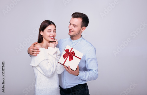 Excellent gentleman in a pale blue shirt acquired lovely enchanted lady in knitted sweater with dark hair