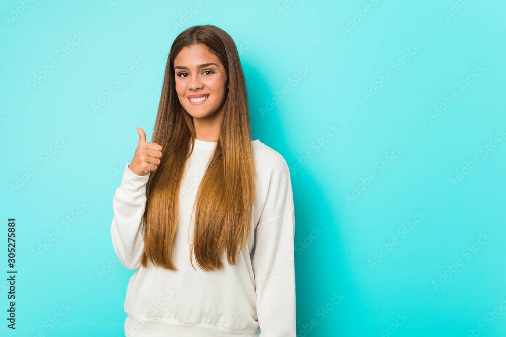 Young slim woman smiling and raising thumb up Young slim woman smiling and raising thumb up