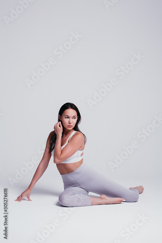 Sporty young woman doing yoga practice isolated on white background - concept of healthy life and natural balance between body and mental development © DmitryStock