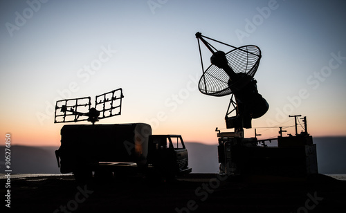Satellite dishes or radio antennas against evening sky. Selective focus photo