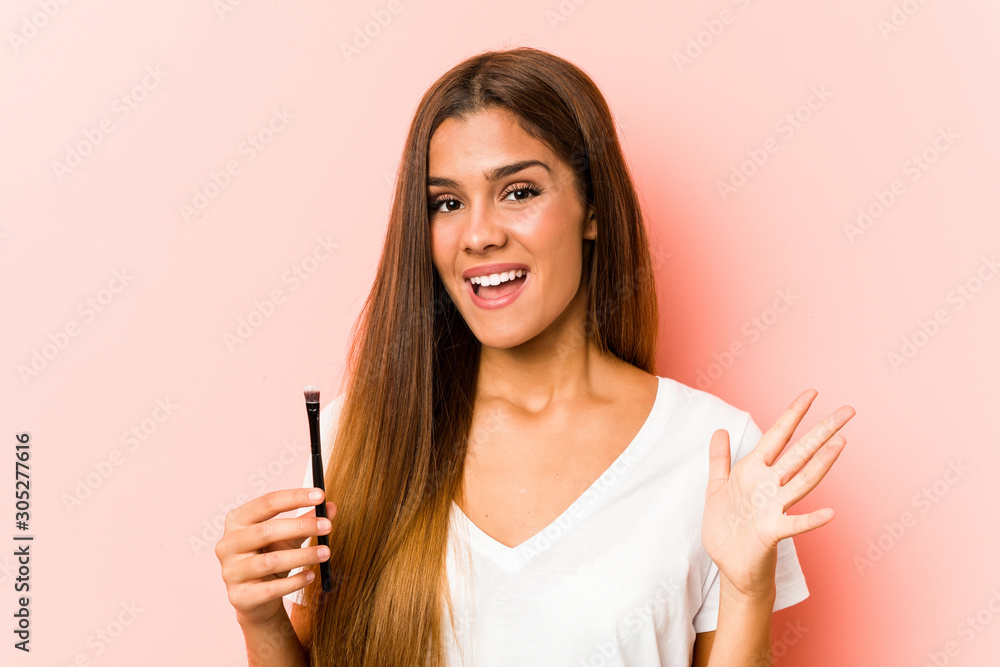Young caucasian woman holding an skinbrush celebrating a victory or success Young caucasian woman holding an skinbrush celebrating a victory or success