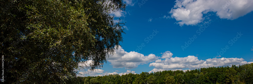 Rural landscape blue sky with clouds and meadow on a sunny day, panorama.