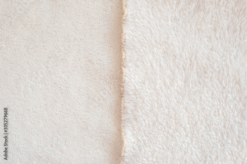 The front and back side of the soft cozy white fabric with pile lies evenly and divides the frame into two halves. Fur light cream plaid.