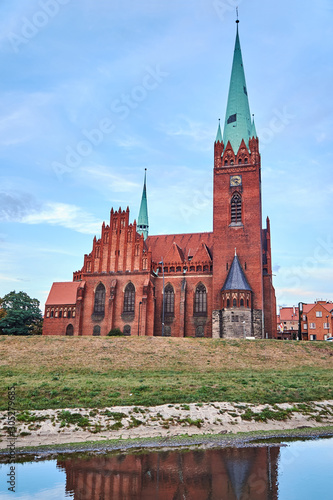 the river and neo-Gothic church with belfry in Legnica in Poland..
