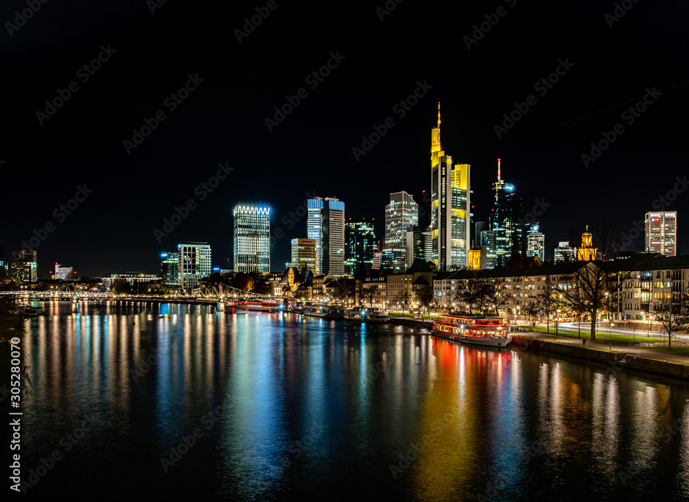 frankfurt skyline at night with colorful reflections in the main river, frankfurt am main, germany