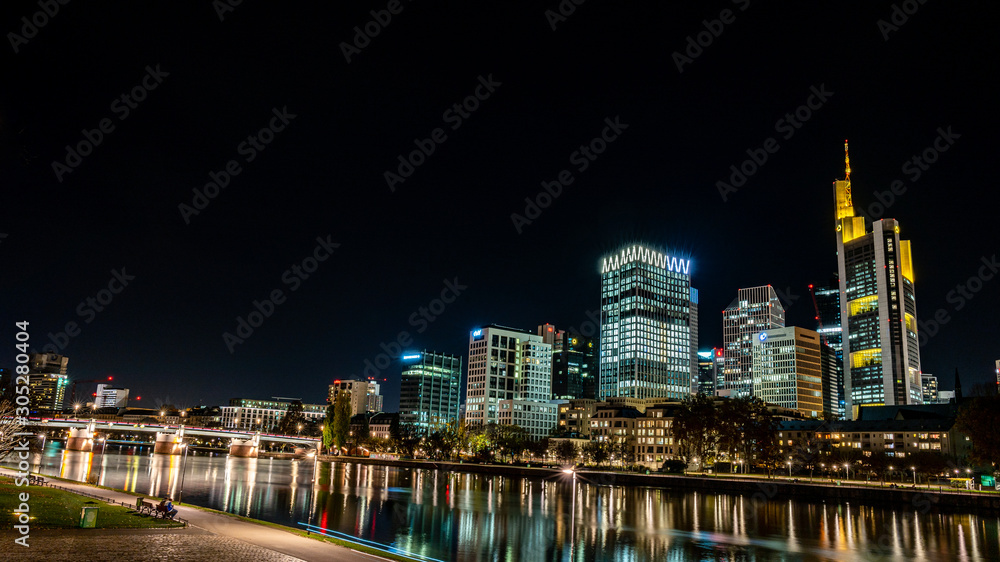 frankfurt skyline at night with colorful reflections in the main river, frankfurt am main, germany