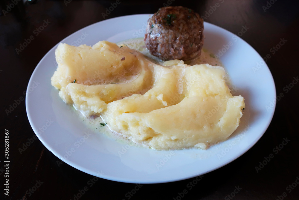 homemade patty with gravy and mashed potatoes on a plate  