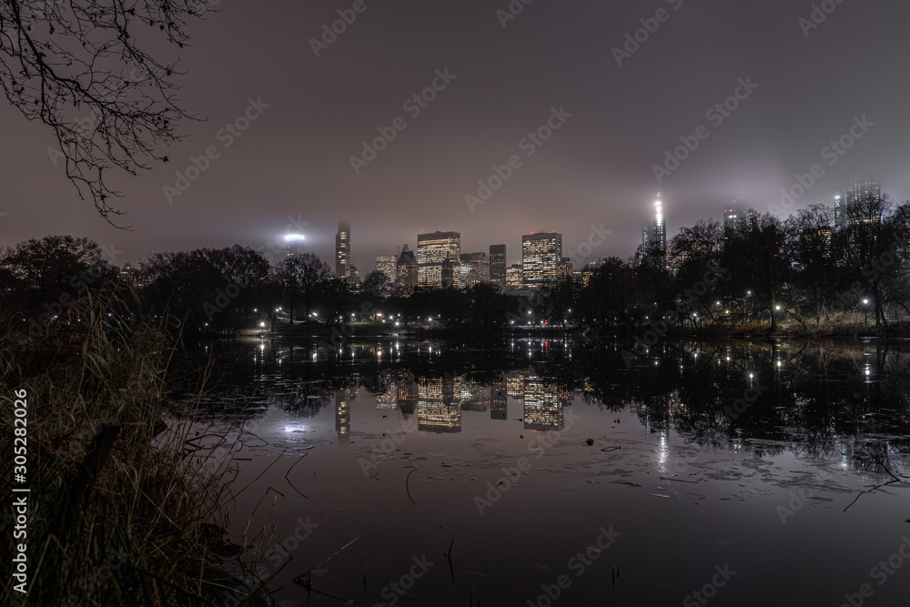 long exposure picture from the central park to the skyscrapers of new york during a foggy night