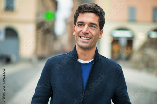 Smiling young man walking in a city