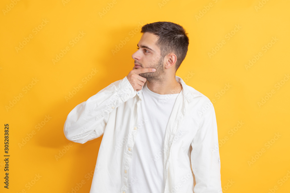 young man with thoughtful beard in color background young man with thoughtful beard in color background