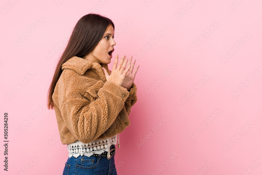 Young cute woman shouts loud, keeps eyes opened and hands tense. Young cute woman shouts loud, keeps eyes opened and hands tense.