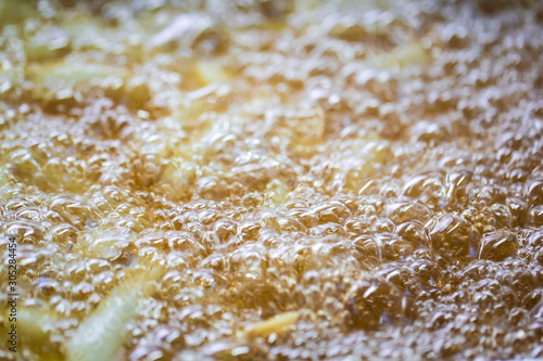 Close-up of hot boiling oil, deep frying French fries