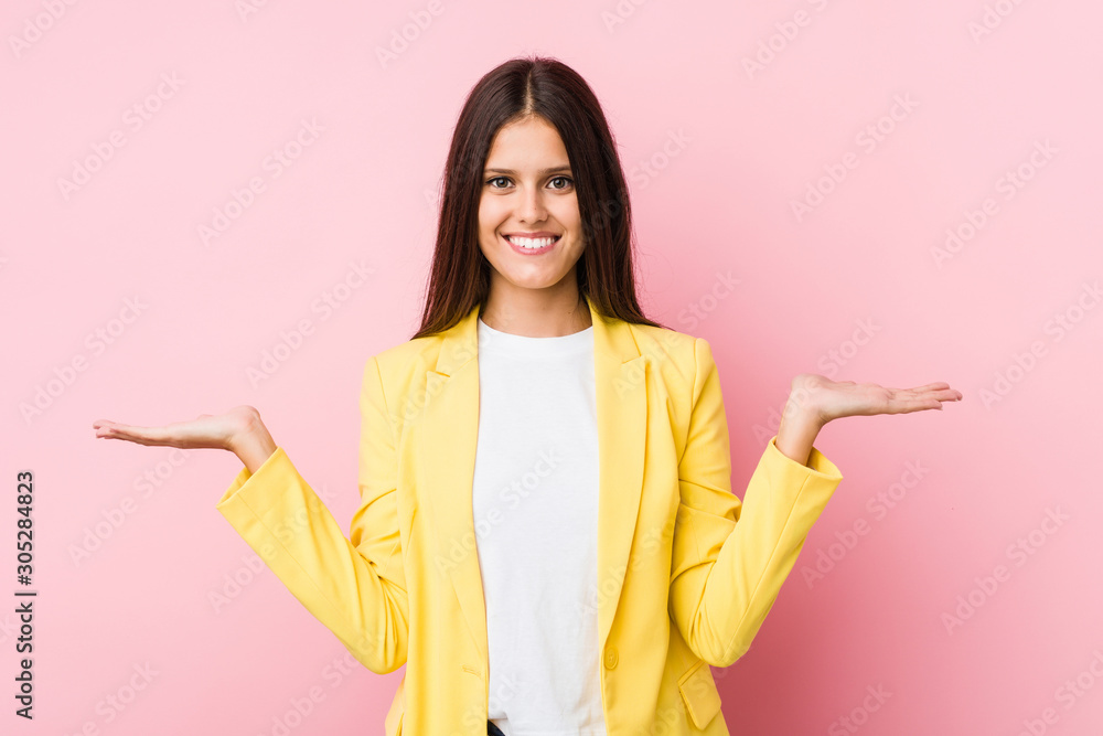 Young business woman makes scale with arms, feels happy and confident. Young business woman makes scale with arms, feels happy and confident.