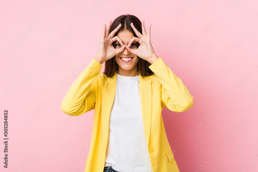 Young business woman showing okay sign over eyes Young business woman showing okay sign over eyes