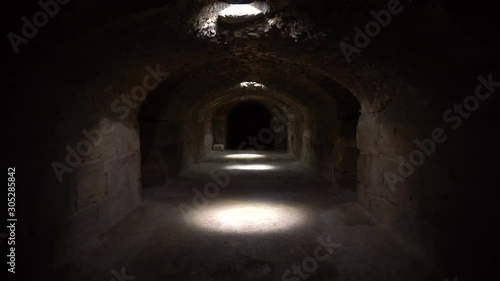 Pass through a long and dark Roman basement. Basement under the Amphitheater in El Jem, Tunis. Ancient roman building. The camera is approaching