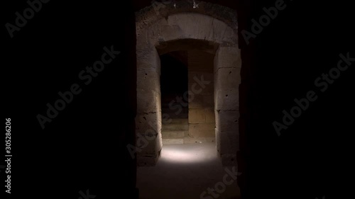 Pass through a long and dark Roman basement. Basement under the Amphitheater in El Jem, Tunis. Ancient roman building. The camera is approaching