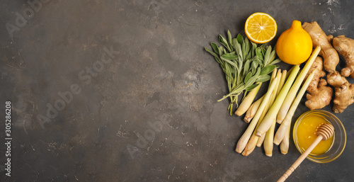 Photography Fresh ingredients ginger, lemongrass, sage, honey and lemon for healthy antioxidant and anti-inflammatory ginger tea on dark background with copy space
