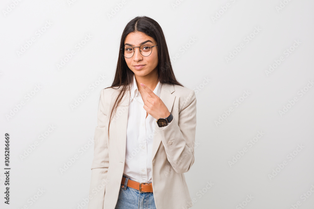 Young business arab woman isolated against a white background pointing with finger at you as if inviting come closer. Young business arab woman isolated against a white background pointing with finger at you as if inviting come closer.