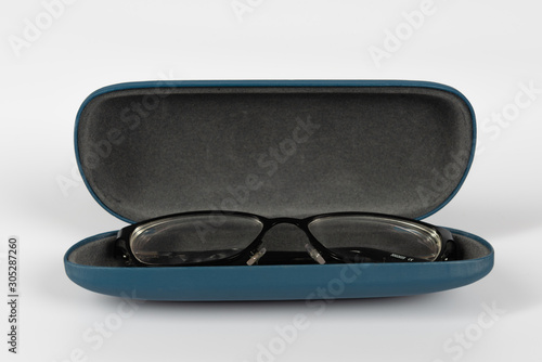 An open isolated glasses case containing a black pair of glasses set against a white background
