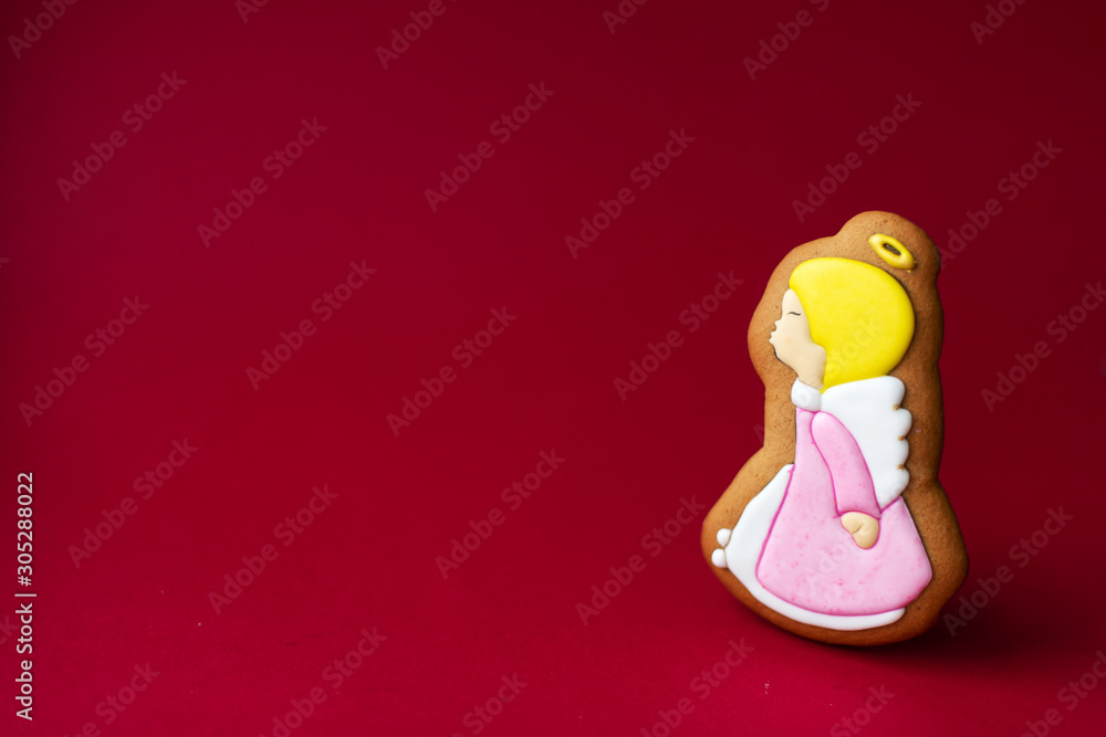 gingerbread cookie of little cute angels on red background. Traditional Christmas food. Christmas and New Year holiday concept. gingerbread cookie of little cute angels on red background. Traditional Christmas food. Christmas and New Year holiday concept.
