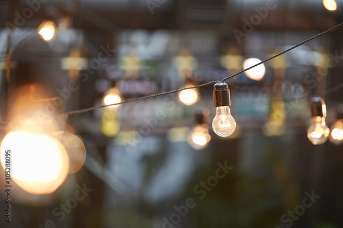 Background image of outdoor lighting garlands   focus on classic light bulb with wiring  copy space