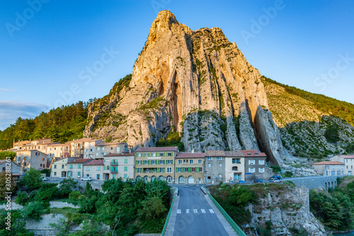 Canvas Print Small French town under a big rock.