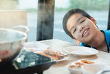Disabled child on wheelchair eating Shabu, His favorite Asian food, Restaurant background, Special children's lifestyle,Life in the education age of special need children,Happy disability kid concept.