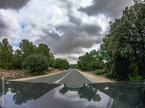 pov driving a car on a straight two way road in Murcia some trees plantation