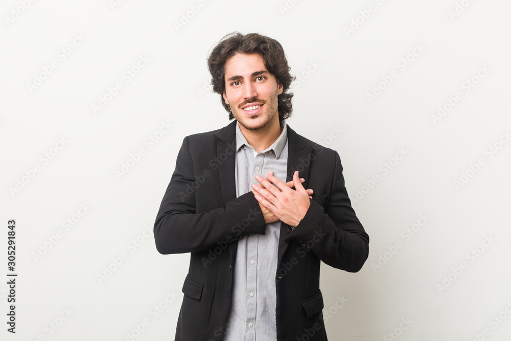 Young business man against a white background has friendly expression, pressing palm to chest. Love concept. Young business man against a white background has friendly expression, pressing palm to chest. Love concept.