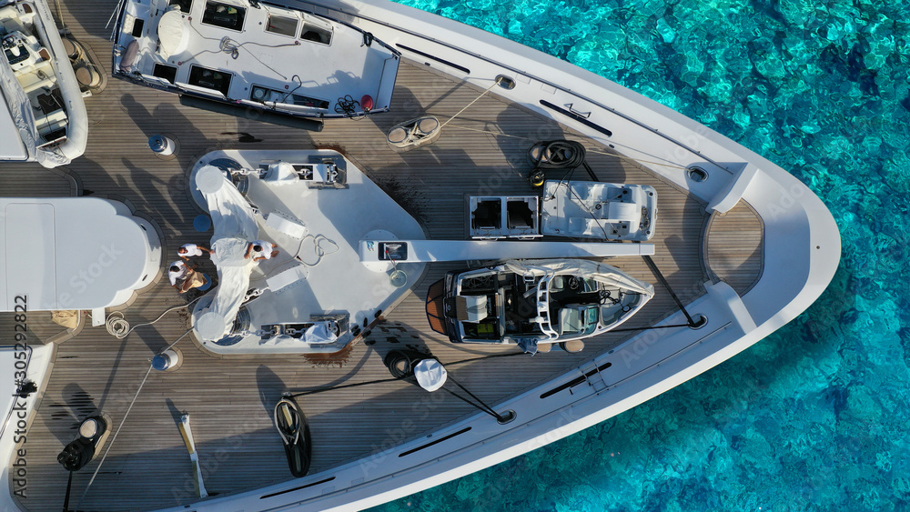 Aerial top down detail photo of yacht nose docked in tropical exotic bay with turquoise clear sea Aerial top down detail photo of yacht nose docked in tropical exotic bay with turquoise clear sea