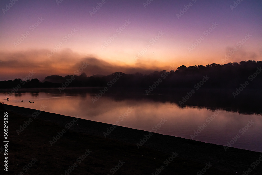 Soonenaufgang über dem See bei Nebel