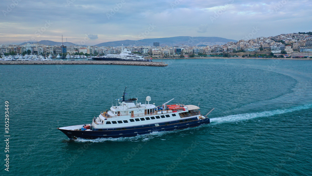 Aerial drone photo of yacht cruising in Mediterranean open sea bay at sunset with beautiful colours