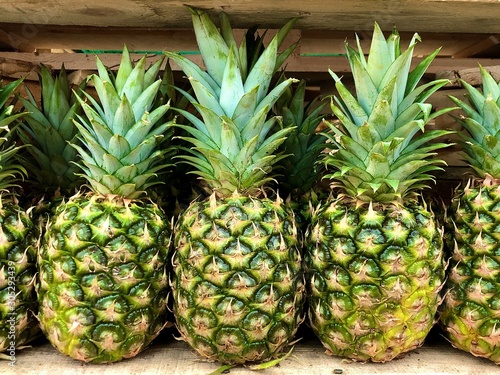 Big pineapple, close up. Exotic fruits at the grocery store. Different varieties of pineapples in a supermarket shelf.