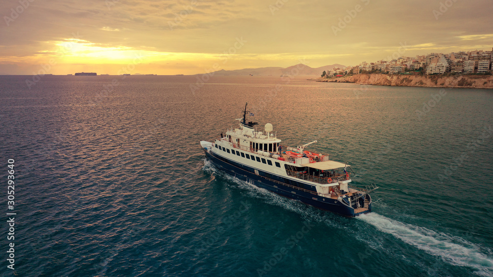 Aerial drone photo of yacht cruising leaving Marina Zeas at sunset with beautiful colours, Piraeus, Attica, Greece Aerial drone photo of yacht cruising leaving Marina Zeas at sunset with beautiful colours, Piraeus, Attica, Greece
