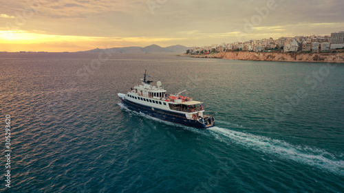 Aerial drone photo of yacht cruising leaving Marina Zeas at sunset with beautiful colours  Piraeus  Attica  Greece